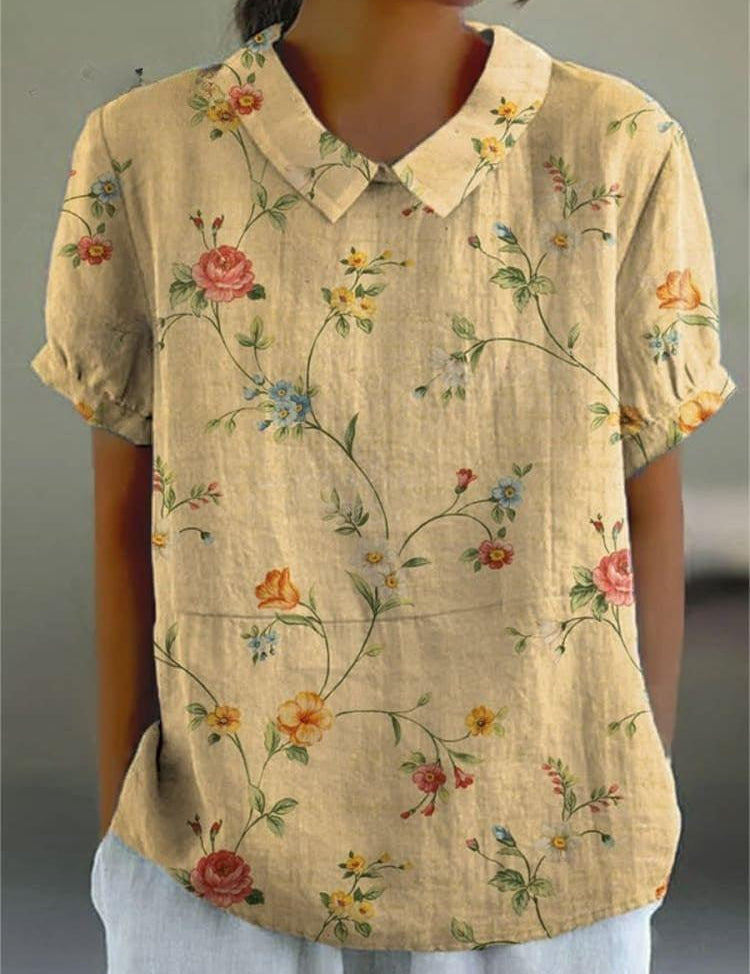 Camicia donna in lino beige con colletto, maniche corte e stampa floreale colorata. Elegante e casual, perfetta per la moda estiva.