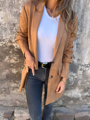 Giacca in pelle marrone da donna, abbinata a maglietta bianca e jeans neri. Look casual chic, moda autunnale, stile urbano elegante.