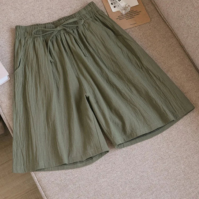 Pantaloncini corti verdi in cotone, stile casual, con elastico in vita e tasche laterali, ideali per l'estate e il tempo libero.
