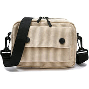 Borsa a tracolla in velluto a coste beige con tasca frontale, chiusura a zip, bottoni neri e tracolla regolabile. Accessorio moda casual.