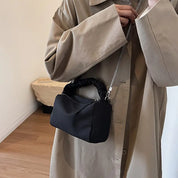 Cappotto beige elegante con borsa a tracolla nera in tessuto, design moderno, ideale per moda autunnale. Accessorio chic per look casual.