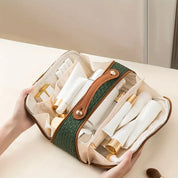 Borsa da toilette verde in pelle con cerniera, contenente flaconi e tubetti cosmetici bianchi. Ideale per viaggi, organizzazione prodotti bellezza.