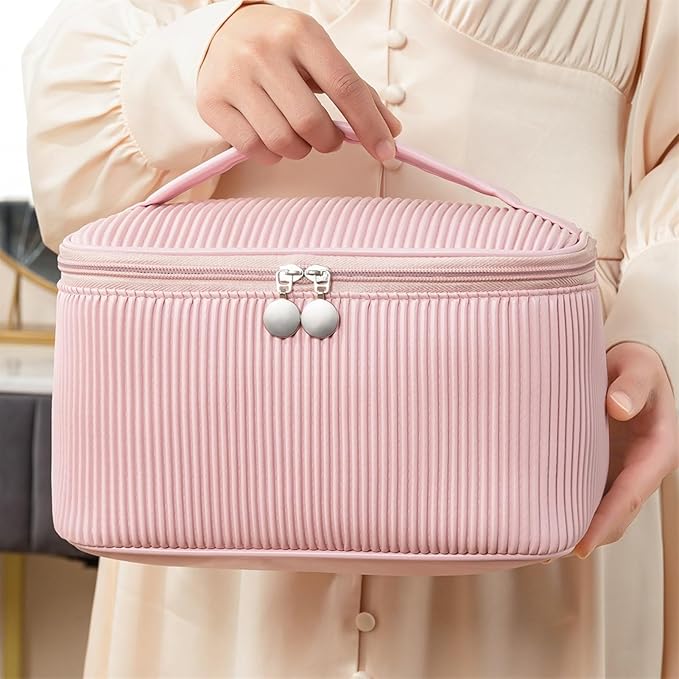 Astuccio cosmetico rosa con manico, design a coste, chiusura a zip, ideale per organizzare trucchi e accessori. Perfetto per viaggi e uso quotidiano.
