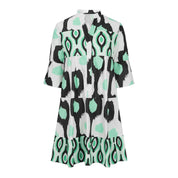 Abito corto donna con stampa geometrica verde, bianco e nero, maniche a tre quarti, scollo a V. Moda estiva, stile casual chic.