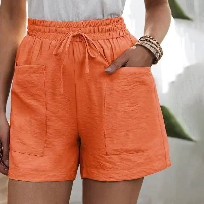 Shorts arancioni da donna con tasche, elastico in vita e laccio. Moda estiva casual, tessuto leggero. Ideali per look quotidiani e vacanze.