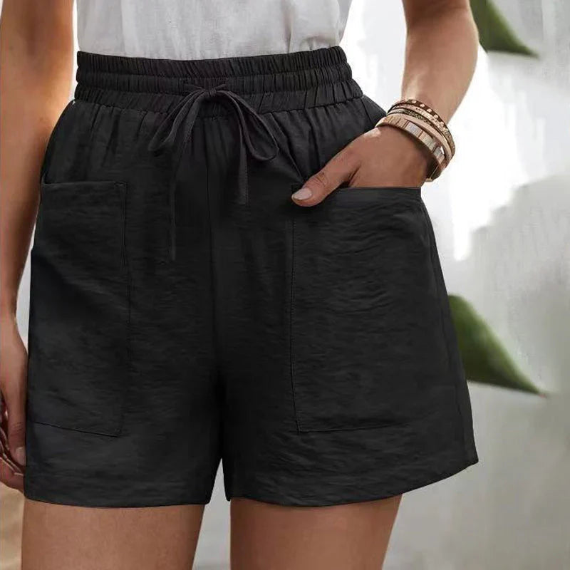 Shorts neri da donna con tasche, elastico in vita e laccio, indossati con top bianco. Stile casual estivo, moda femminile comoda.