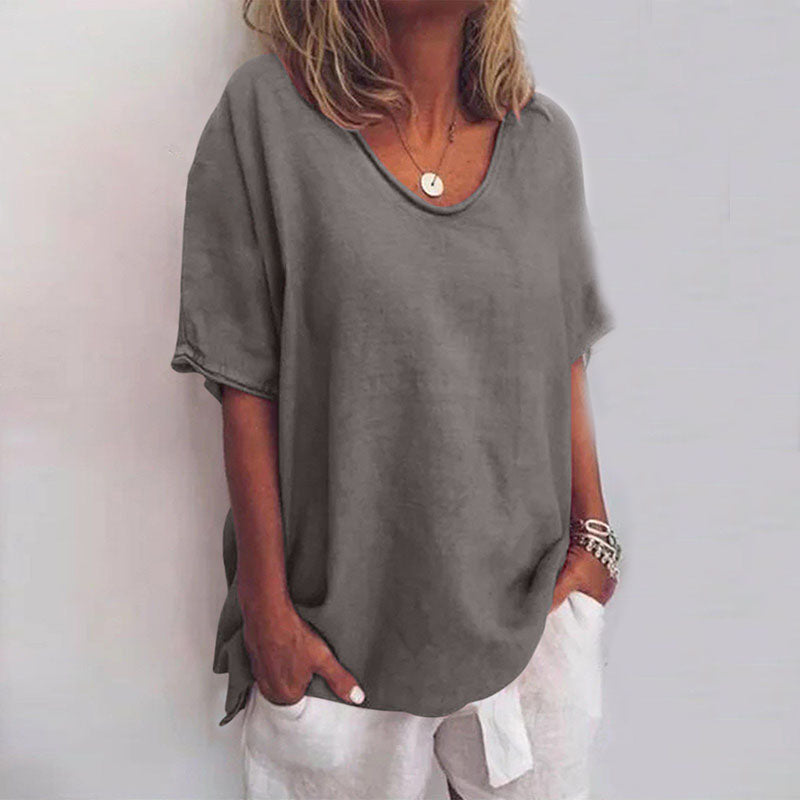 Maglietta grigia donna, maniche corte, scollo rotondo, stile casual, tessuto morbido, abbinata a pantaloni bianchi. Moda estiva femminile.