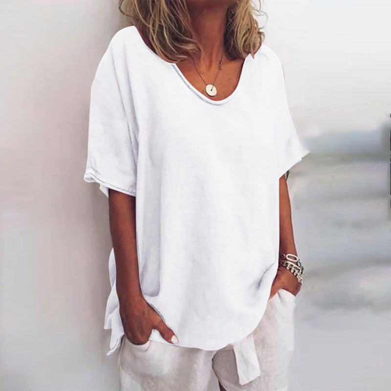 Maglietta bianca da donna, maniche corte, scollo rotondo, stile casual estivo, tessuto leggero, abbinata a pantaloni bianchi.