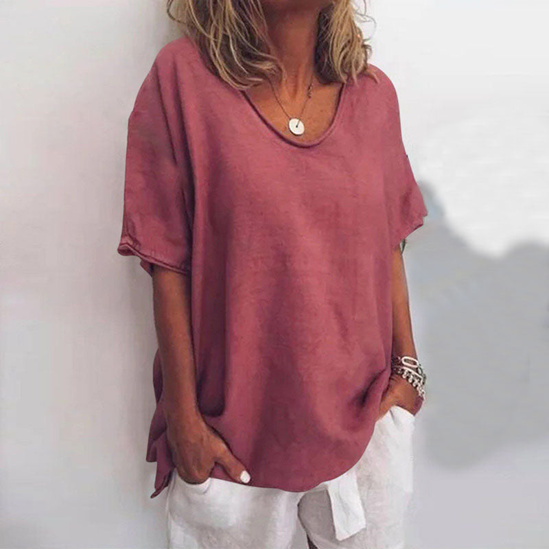 Donna con maglietta oversize rosa, maniche corte, scollo rotondo, abbinata a pantaloni bianchi. Stile casual estivo, moda femminile.
