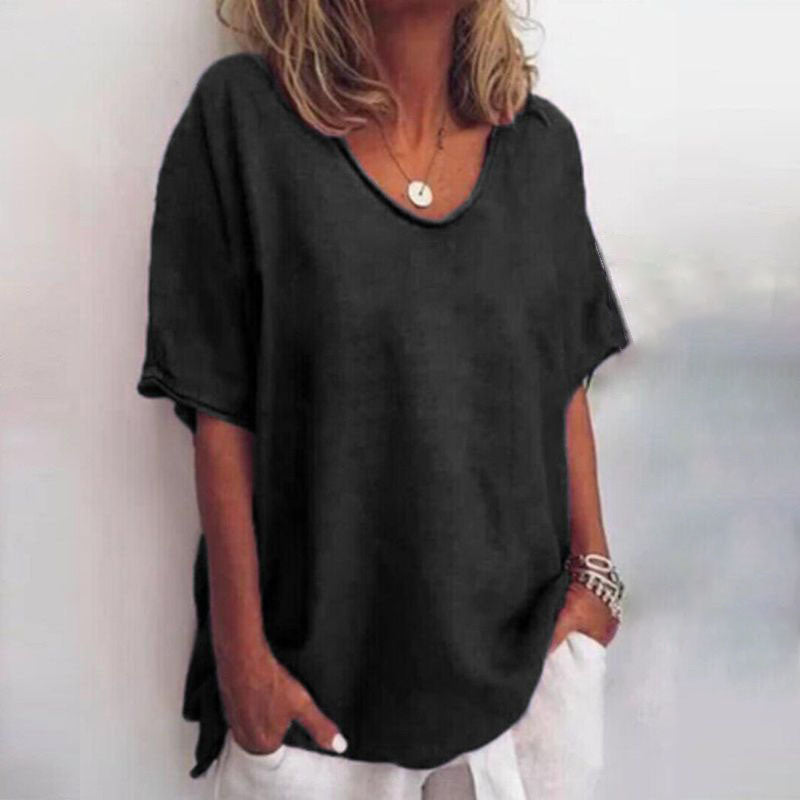 Donna con maglietta nera oversize, maniche corte, scollo a V, abbinata a pantaloni bianchi. Stile casual, moda estiva, abbigliamento femminile.