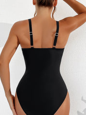 Donna in costume intero nero, spalline regolabili, vista posteriore. Moda mare, abbigliamento estivo, costume da bagno elegante.