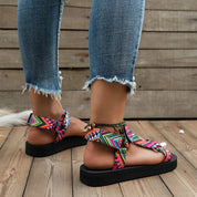 Sandali estivi colorati con zeppa piatta, cinturini regolabili, indossati con jeans strappati. Scarpe donna moda casual, stile boho chic.