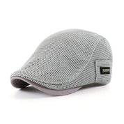 Cappello piatto grigio in rete traspirante, stile estivo, con etichetta laterale. Accessorio moda uomo, leggero e confortevole.