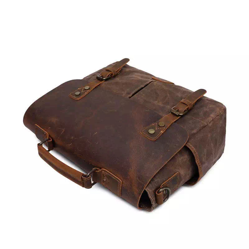 Borsa messenger in pelle marrone vintage, design elegante con fibbie e manico robusto. Ideale per lavoro e viaggio. Accessorio moda uomo.