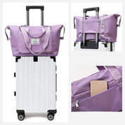 Borsa da viaggio pieghevole viola su trolley bianco, tasca frontale con zip, manici resistenti, ideale per viaggi, bagaglio a mano, organizzazione.