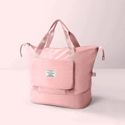 Borsa da viaggio rosa in tessuto impermeabile con manici rinforzati, tasca frontale con zip e scomparto inferiore. Elegante e pratica per viaggi.