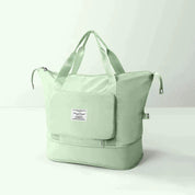 Borsa da viaggio verde menta con manici, tasca frontale con zip e scomparto inferiore. Design elegante e spazioso per viaggi e weekend.