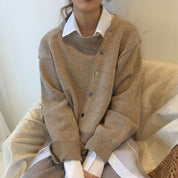 Donna con maglione beige oversize e camicia bianca, moda autunno inverno, abbigliamento casual elegante, tendenze abbigliamento femminile.