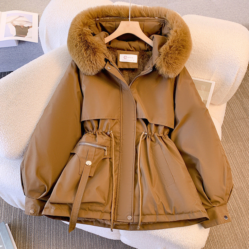 Giacca invernale marrone con cappuccio in pelliccia sintetica, tasche multiple e cintura. Elegante e calda, ideale per la moda femminile invernale.