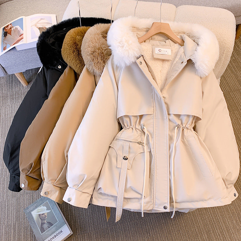 Giacche invernali con cappuccio in pelliccia sintetica, colori nero, marrone e beige, su appendiabiti. Moda donna, abbigliamento caldo, tendenze 2023.