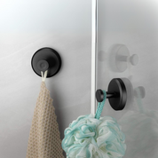 Gancio adesivo nero su vetro doccia con spugna e rete appese, accessorio bagno moderno, resistente all'acqua, facile installazione.