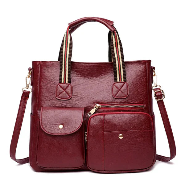 Borsa a tracolla in pelle rossa con tasche multiple, manici a righe, design elegante e funzionale, perfetta per moda donna e uso quotidiano.