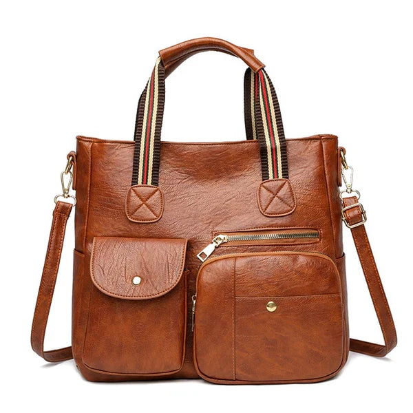 Borsa a tracolla in pelle marrone con manici a righe, tasche frontali con zip e bottoni. Elegante e pratica per uso quotidiano.