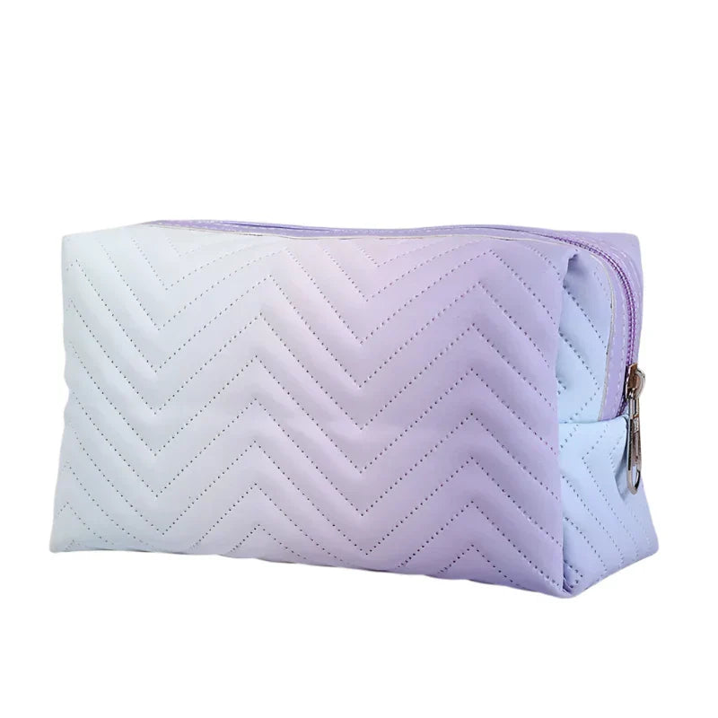 Astuccio da toilette trapuntato bianco con motivo a zigzag, chiusura a zip, ideale per cosmetici e accessori da viaggio.