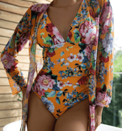 Costume intero donna floreale arancione con copricostume abbinato, design elegante e colorato, perfetto per l'estate e la spiaggia.