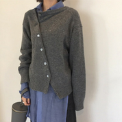 Donna con cardigan grigio asimmetrico e camicia blu, moda casual autunnale. Stile elegante e moderno, abbigliamento femminile trendy.