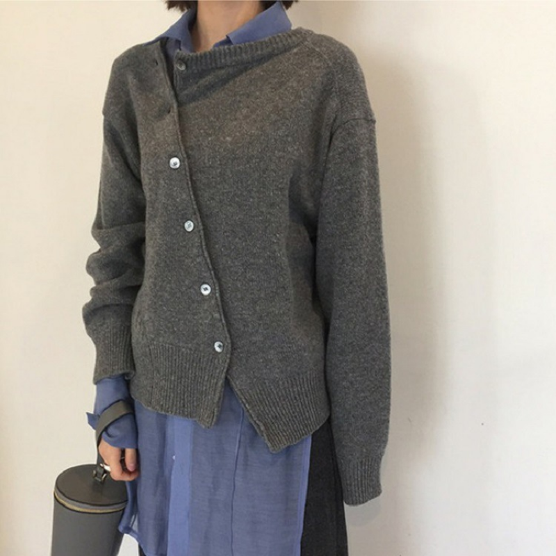 Donna con cardigan grigio asimmetrico e camicia blu, moda casual autunnale. Stile elegante e moderno, abbigliamento femminile trendy.