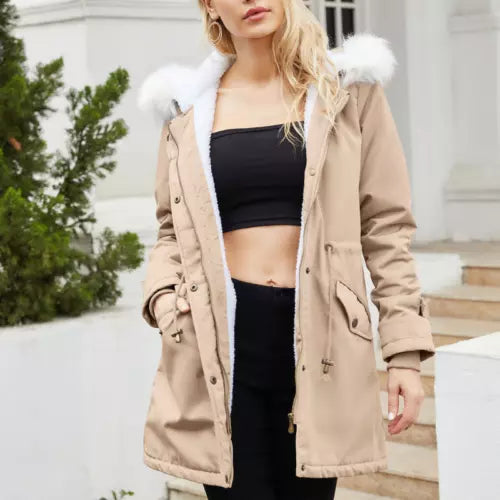 Giacca parka beige da donna con cappuccio in pelliccia sintetica bianca, indossata su top nero. Moda invernale, abbigliamento casual elegante.
