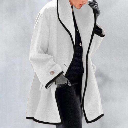 Cappotto bianco elegante con bordi neri, indossato da una persona con guanti neri. Moda invernale, abbigliamento donna, stile sofisticato.