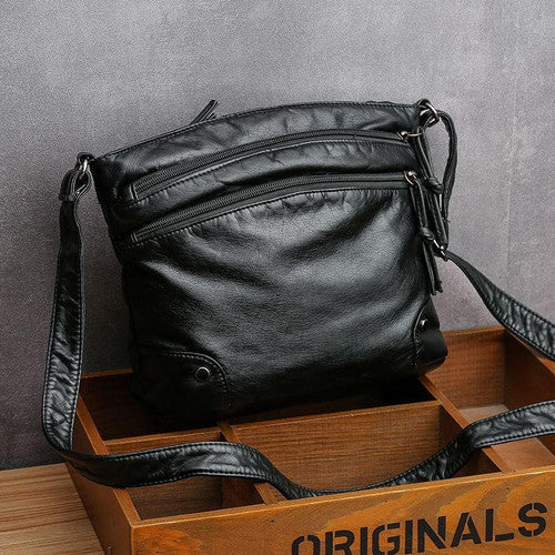 Borsa a tracolla in pelle nera, design elegante con doppie cerniere, ideale per moda donna, accessori di lusso, stile casual chic.
