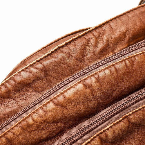 Zaino in pelle marrone con cerniera, texture vintage. Accessorio moda uomo/donna, ideale per viaggi e uso quotidiano. Elegante e resistente.