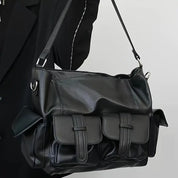 Borsa a tracolla in pelle nera con tasche frontali, design elegante e moderno, ideale per moda urbana e look casual. Accessorio versatile e di tendenza.