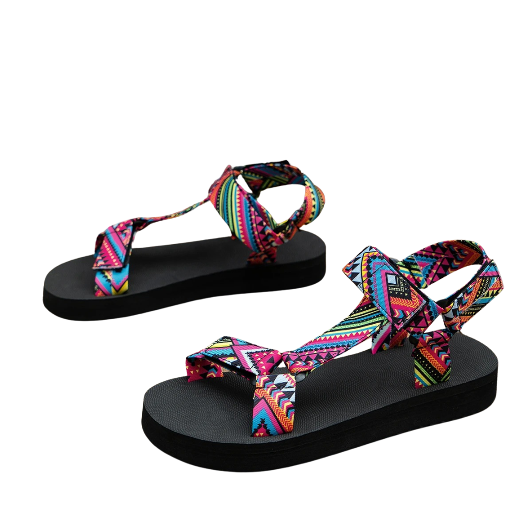 Sandali estivi da donna con suola nera e cinturini multicolore a motivi geometrici. Calzature comode e alla moda per l'estate.