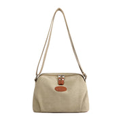 Borsa a tracolla beige in tela con chiusura a zip e dettagli in pelle marrone, design elegante e pratico per uso quotidiano.