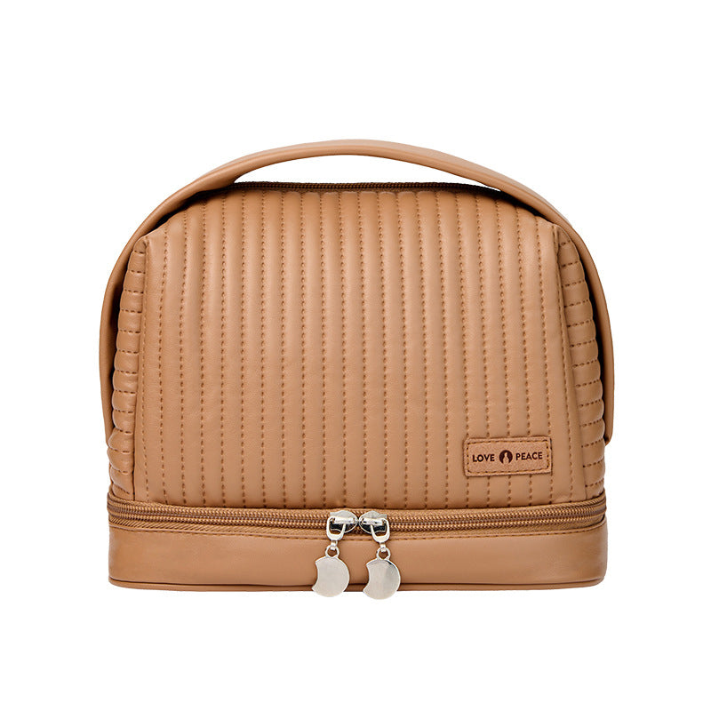 Borsa cosmetica beige in pelle sintetica con manico, chiusura a zip doppia, design trapuntato, ideale per viaggio e organizzazione trucco.