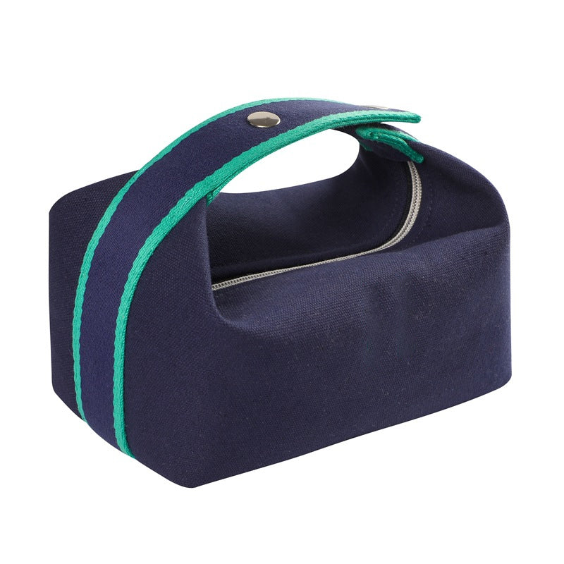 Borsa da toilette blu in tessuto con manico verde, chiusura a zip, design moderno. Accessorio da viaggio pratico ed elegante.