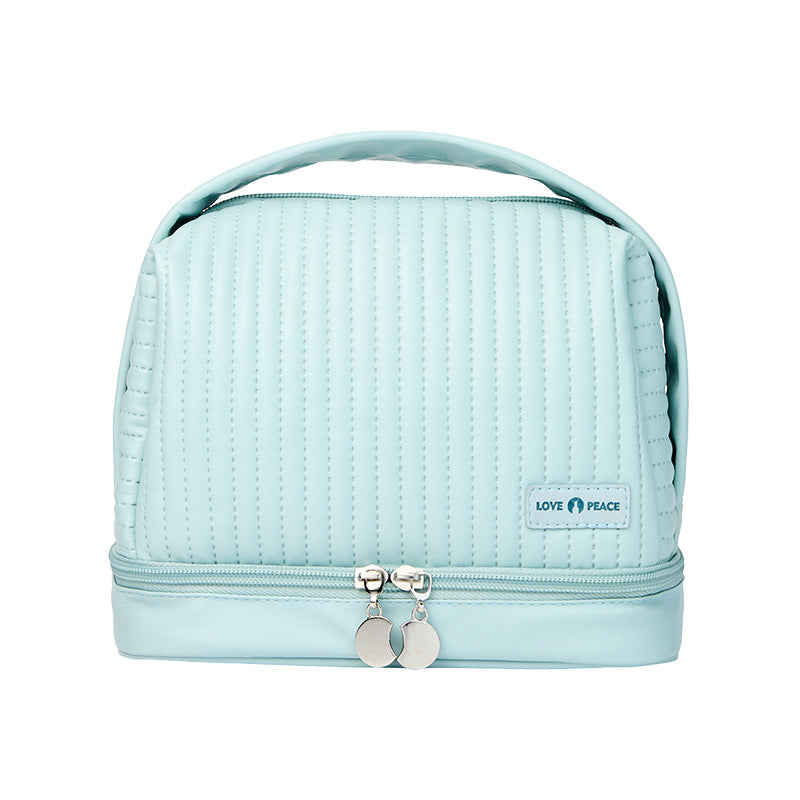 Borsa cosmetica azzurra con manico, design trapuntato, doppia cerniera e logo "Love Peace". Ideale per organizzare trucchi e accessori da viaggio.
