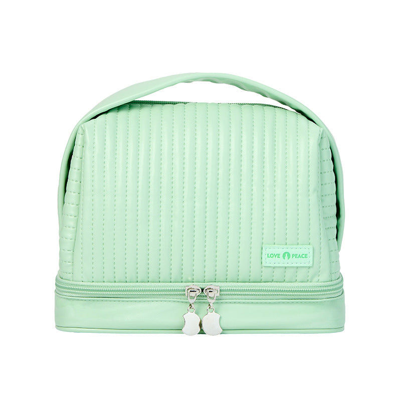 Borsa cosmetica verde menta con manico, doppia cerniera e design trapuntato. Ideale per organizzare trucchi e accessori da viaggio.