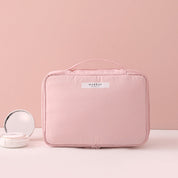 Borsa trucco rosa con manico, design elegante e compatto, ideale per organizzare cosmetici. Perfetta per viaggi e uso quotidiano.