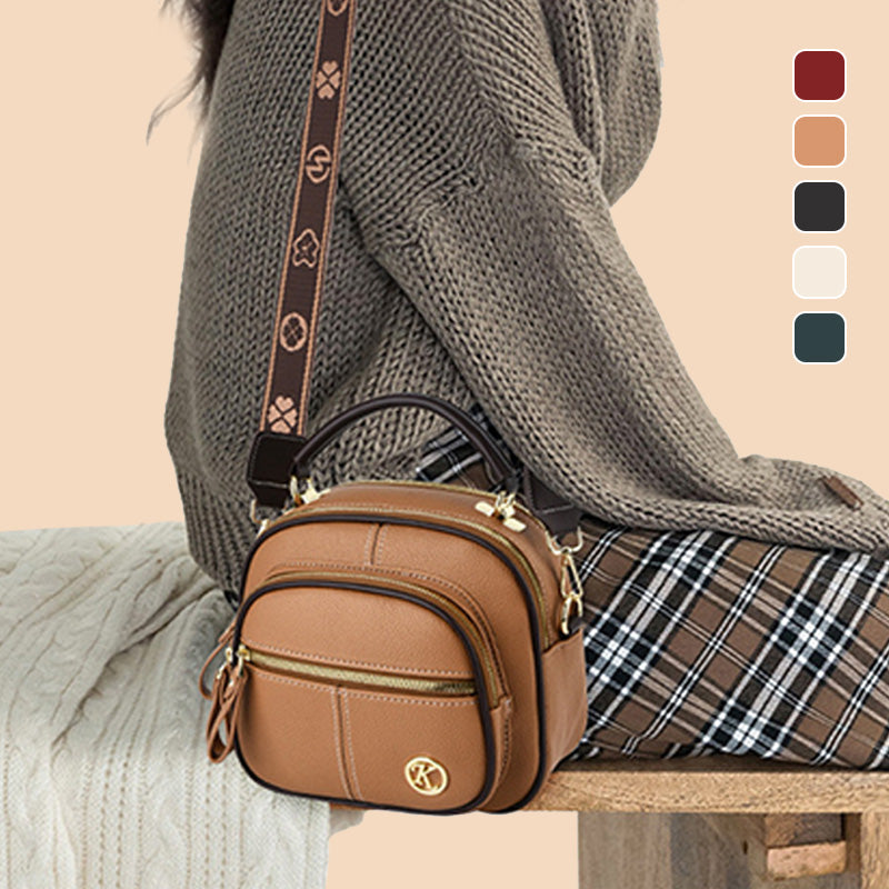Borsa a tracolla marrone in pelle con dettagli dorati, indossata su abbigliamento autunnale. Design elegante, perfetta per moda casual e urbana.