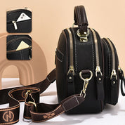 Borsa a tracolla in pelle nera con doppia cerniera, tasche multiple e dettagli in metallo dorato. Design elegante e funzionale per uomo e donna.