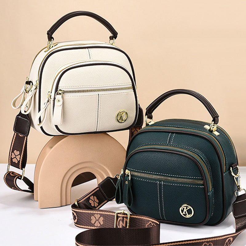 Due borse a tracolla in pelle, una bianca e una verde, con dettagli dorati e cinturini decorati. Design elegante e moderno, perfette per ogni occasione.