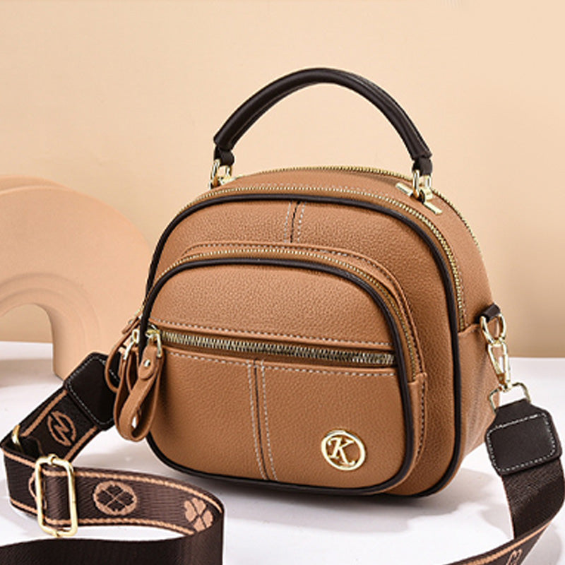 Borsa a tracolla in pelle marrone con manico nero, doppia zip, tasche frontali e tracolla regolabile. Elegante e pratica per ogni occasione.