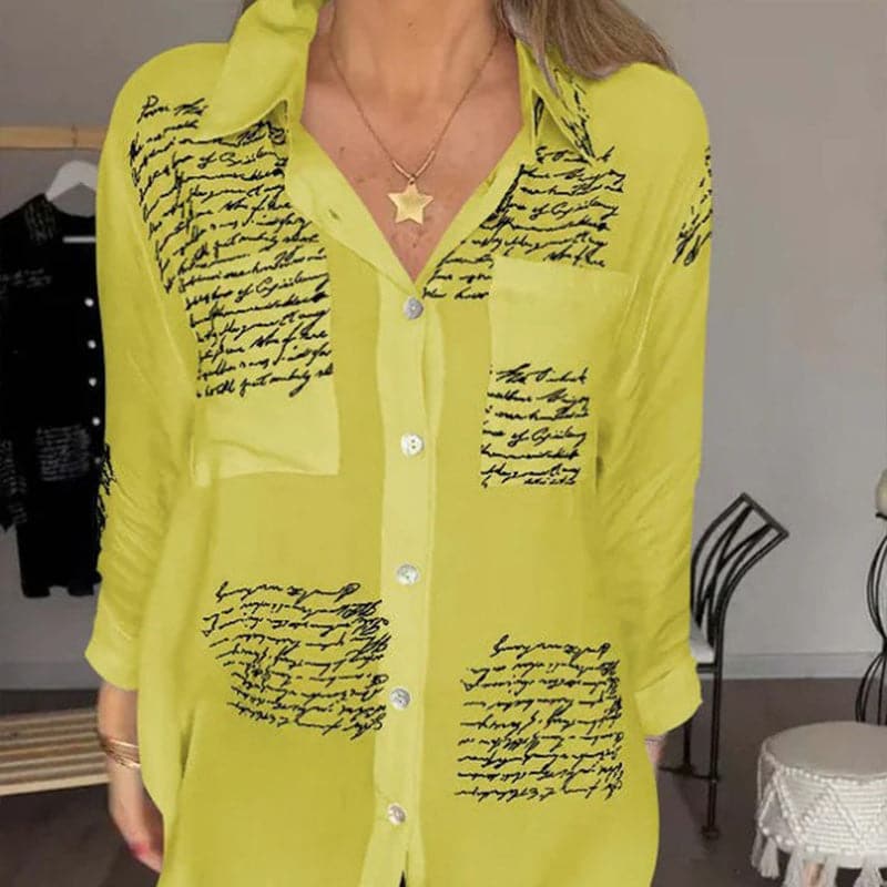 Camicia donna gialla con scritte nere, maniche lunghe, colletto classico, bottoni frontali, stile casual elegante, moda femminile autunno.