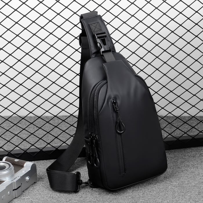 Zaino monospalla nero in pelle sintetica, design moderno, con cerniere multiple, ideale per uomo, perfetto per viaggi e uso quotidiano.