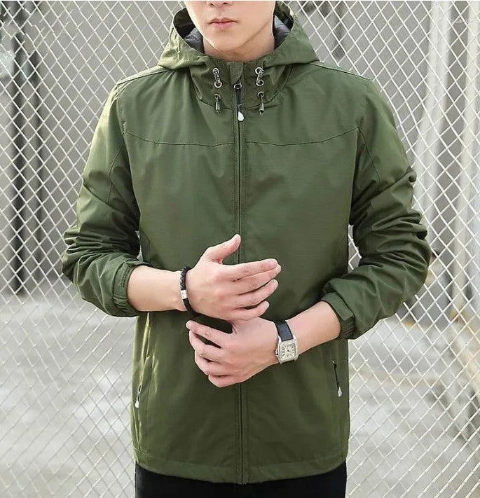 Giacca verde con cappuccio, chiusura a zip, polsini elasticizzati, indossata da uomo. Perfetta per outdoor, moda casual, stile urbano.